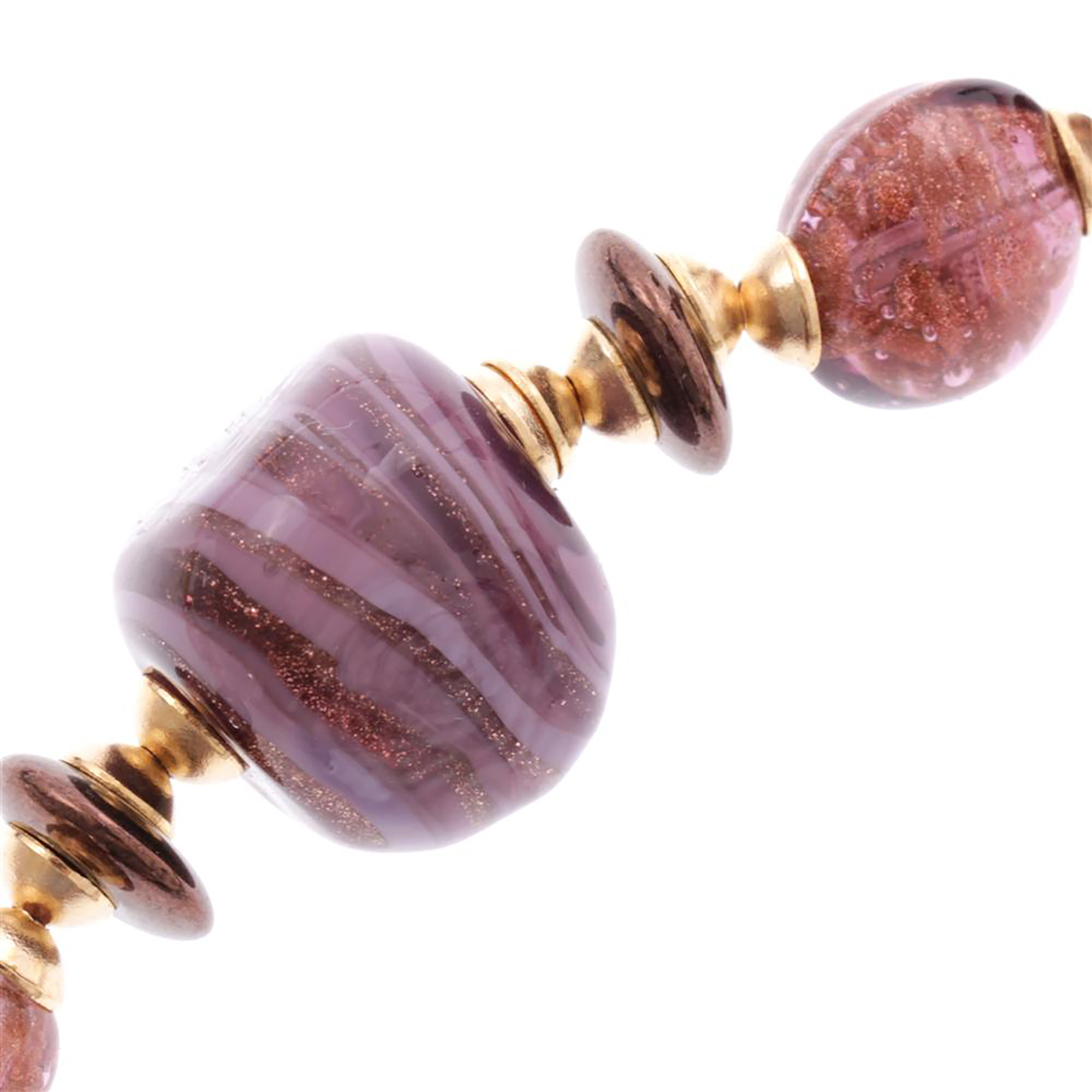 Detail des Torelo Colliers mit gerillter lila Glasperle und goldfarbenen Zwischenstücken